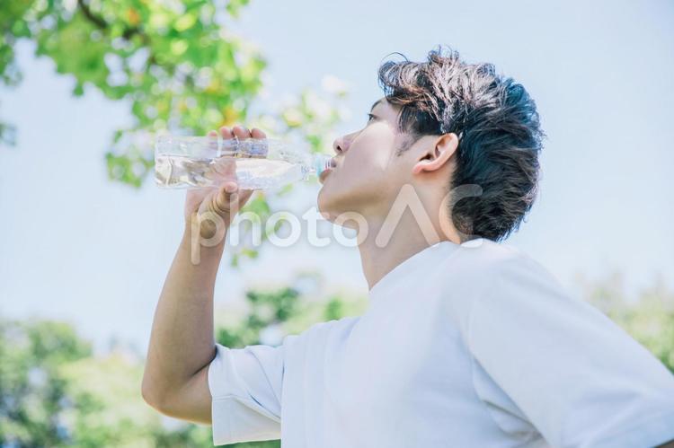 ペットボトルの水を爽やかに飲む男性 熱中症,水分補給,熱中症対策の写真素材
