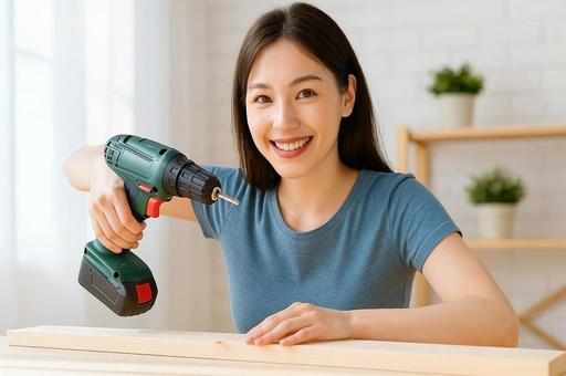 DIYしている若い女性の笑顔・電動ドリル DIYしている若い女性の笑顔・電動ドリルの写真