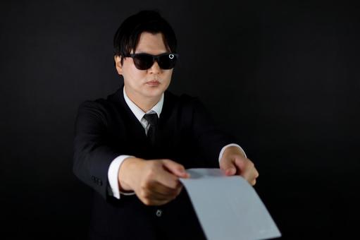 スーツの男性が書類を差し出す スーツの男性が書類を差し出す 男性,スーツ,書類の写真素材