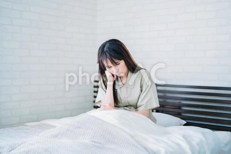 寝起きが悪い女性（頭痛・体調不良） 頭痛,発熱,不眠症の写真素材