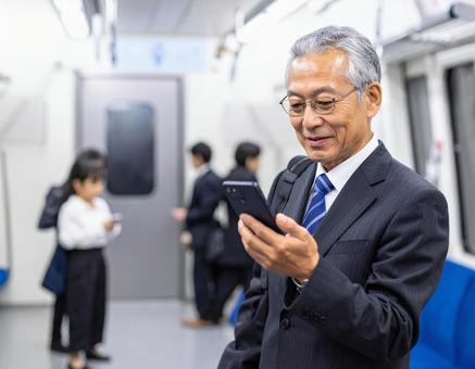 ビジネスシーン・地下鉄出張、スマホを見る ビジネスシーン・地下鉄出張、スマホを見るの写真