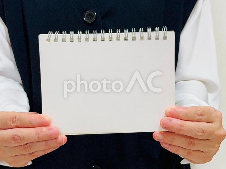 ノートを掲げる女性のアップ 発表,説明,紹介の写真素材