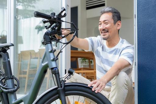 電動自転車をメンテナンスをするミドル男性 電動自転車,男性,ミドルの写真素材
