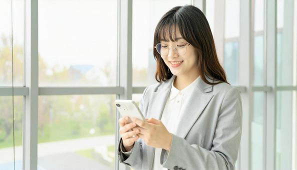 スマホを確認するビジネス女性 スマホを確認するビジネス女性の写真
