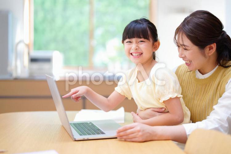 画面を指差し笑う女の子と母 母,娘,笑うの写真素材