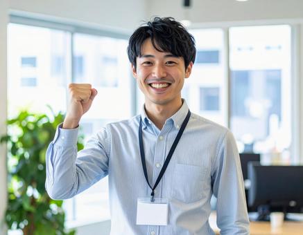 オフィスで笑顔でガッツポーズの男性会社員 オフィスで笑顔でガッツポーズの男性会社員の写真