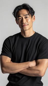 腕組みで自信に満ちた黒いTシャツの男性 腕組みで自信に満ちた黒いTシャツの男性の写真