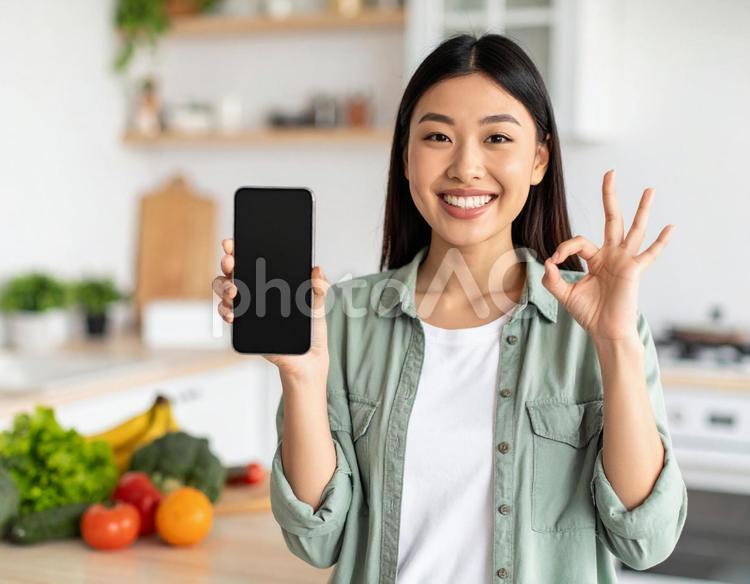 スマートフォンを手にOKサインの女性 女性,スマートフォン,okサインの写真素材
