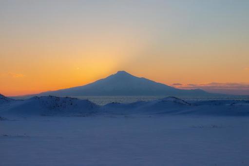 夕焼けを背に映える冬の利尻岳 夕焼けを背に映える冬の利尻岳の写真