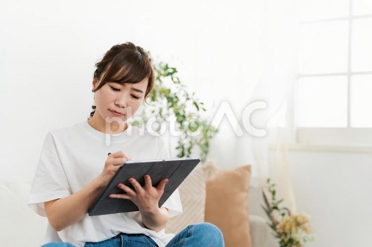 家でタブレットを使う女性（クリエイター） クリエイター,デザイナー,アニメーターの写真素材