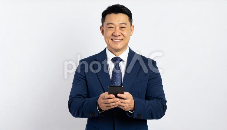 スマホを持つビジネスマン（白背景） ビジネスマン,男性,スマートフォンの写真素材