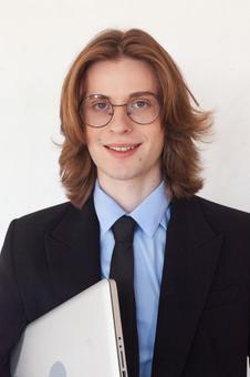 パソコンを待ちカメラ目線の長髪男性 男性,外国人,ノートパソコンの写真素材