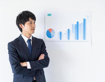 チャートを見て検討する男性ビジネスマン チャートを見て検討する男性ビジネスマンの写真