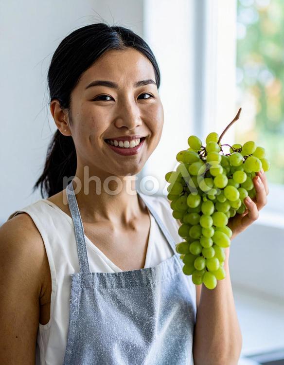 シャインマスカットを手に笑顔の女性 果物,シャインマスカット,ぶどうの写真素材