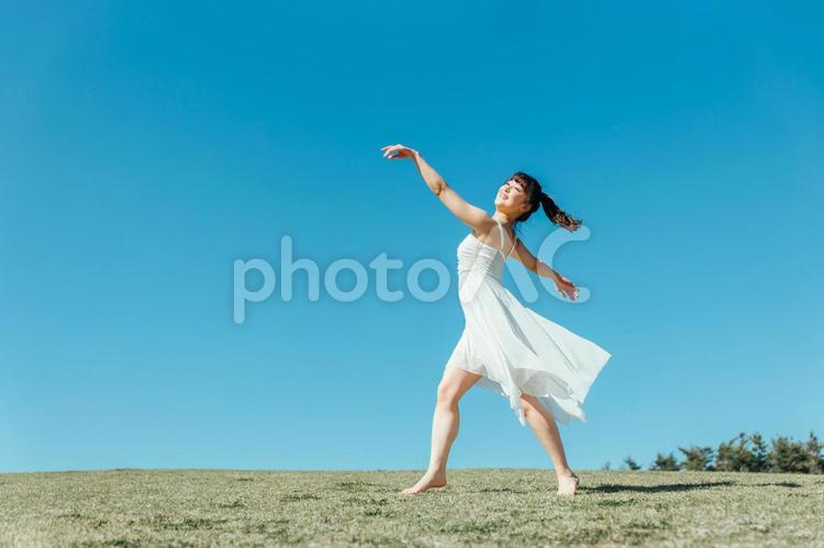 空と白いワンピースの踊る女性 女性,空,美容の写真素材