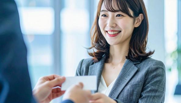 笑顔で名刺交換をするビジネス女性 笑顔で名刺交換をするビジネス女性の写真