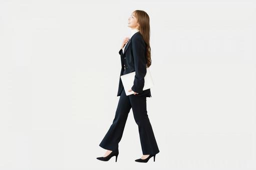 パソコンを持って歩く女性（全身） 女性,パソコン,歩くの写真素材