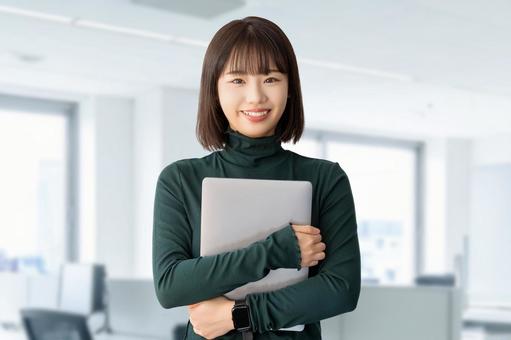 パソコンを持つ女性・ビジネスウーマン パソコンを持つ女性・ビジネスウーマン 女性,パソコン,笑顔の写真素材