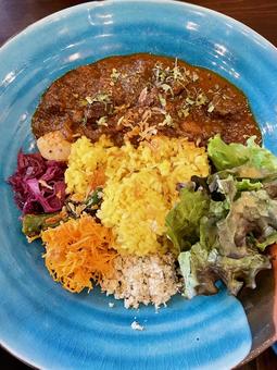 青い皿に盛り付けられたエスニックなカレーの写真