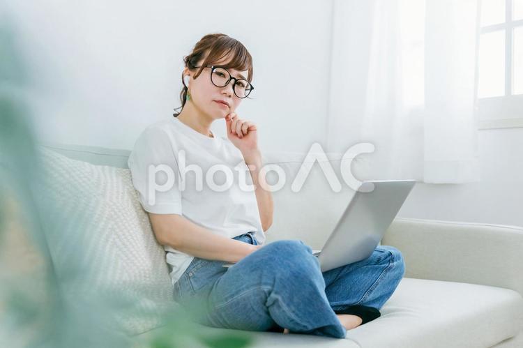 イヤホンとパソコンを使って困る日本人女性 イヤホン,耳,音楽の写真素材
