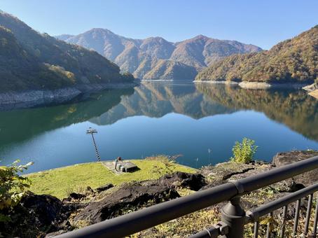 秋の福井県の九頭竜ダム　紅葉に色づく湖の写真