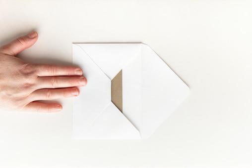 白い洋形封筒を押さえる手 白い洋形封筒を押さえる手 モックアップ,女性,手の写真素材