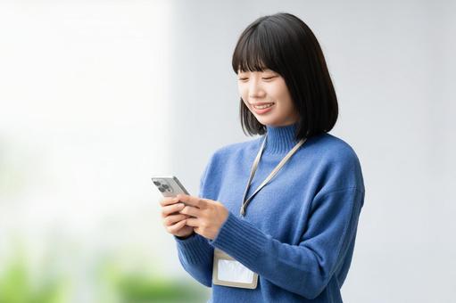 スマホを使う笑顔の女性・ビジネスウーマン 女性,スマホ,スマートフォンの写真素材