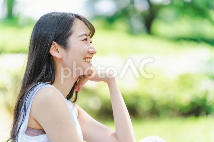 新緑の中で頬杖をつく日本人女性（美容） 女性,横顔,新緑の写真素材