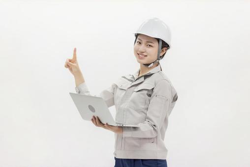 ノートパソコン 作業服の女性 指差し ノートパソコン 作業服の女性 指差し 女性,ヘルメット,ノートパソコンの写真素材