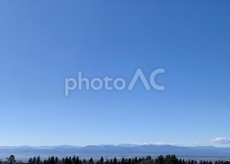 青空に遠く山並み、街、並木 空,青空,青の写真素材