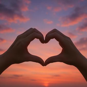 夕焼け 女性の手で作ったハート 夕焼け 女性の手で作ったハートの写真