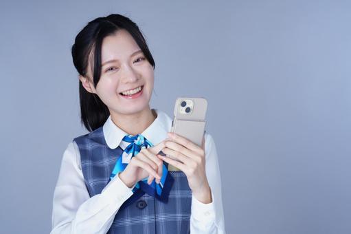 制服姿の女性がスマホを持つ 女性,スマートフォン,持つの写真素材