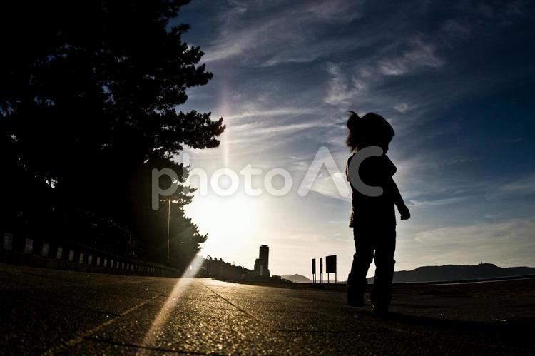 夕暮れ時を歩く少女 夕暮れ,夕方,日暮れの写真素材