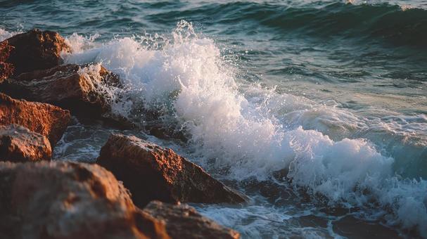 岩肌にぶつかる波しぶきの美しさの写真