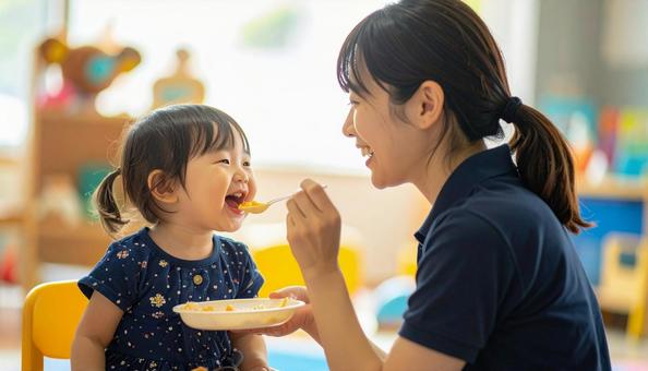 子どもにご飯をあげる保育士 子どもにご飯をあげる保育士の写真