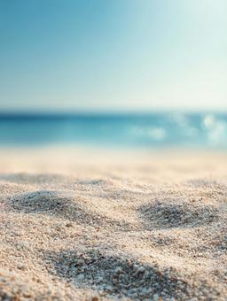 サラサラとした砂浜とぼやけた海の夏の背景 サラサラとした砂浜とぼやけた海の夏の背景の写真