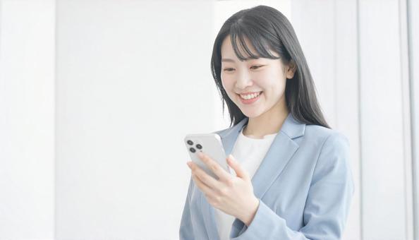 スマホを確認するビジネス女性 スマホを確認するビジネス女性の写真
