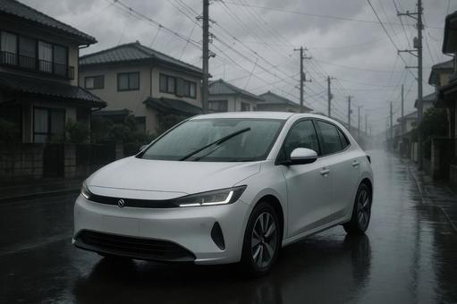 雨の住宅街を走行する電気自動車 雨の住宅街を走行する電気自動車の写真
