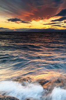 琵琶湖の夕景_岩に打ち寄せる波しぶき 風景,波,夕日の写真素材