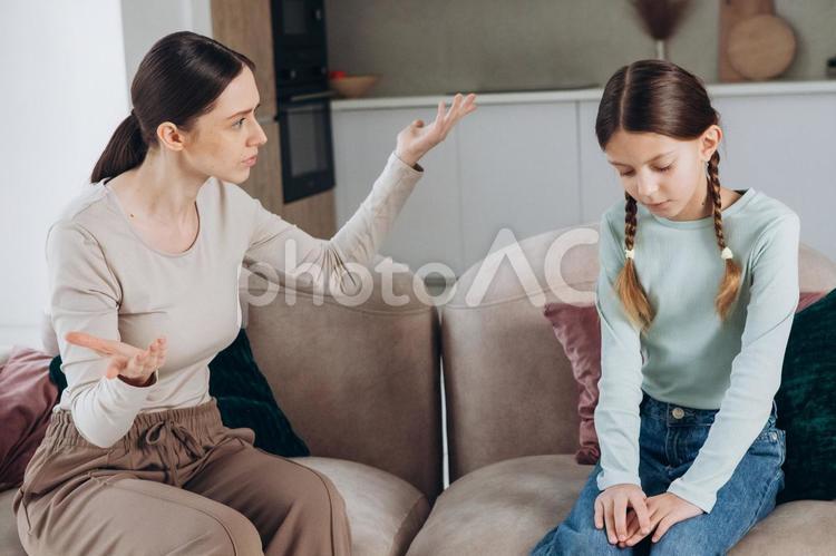 説教している女性の横顔とうつむく女の子 親子,女の子,女性の写真素材