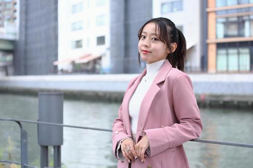 川沿いの公園でカメラ目線の笑顔の女性 女性,可愛い,20代の写真素材