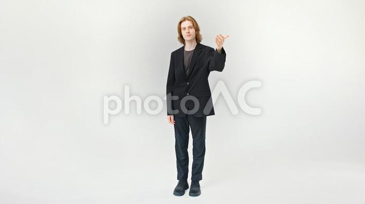 カメラ目線で左手でポーズする男性 男性,微笑む,ポーズの写真素材