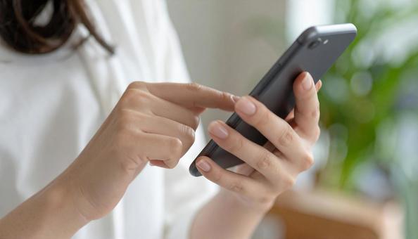 スマホを操作する女性 スマホを操作する女性の写真