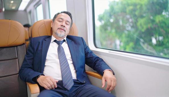 電車内で寝る中年男性 電車内で寝る中年男性の写真