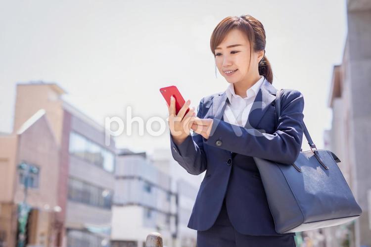 外出する会社員 ビジネスウーマン,スマホ,読むの写真素材