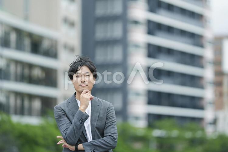 街中で考える男性 持ち家,家,マンションの写真素材