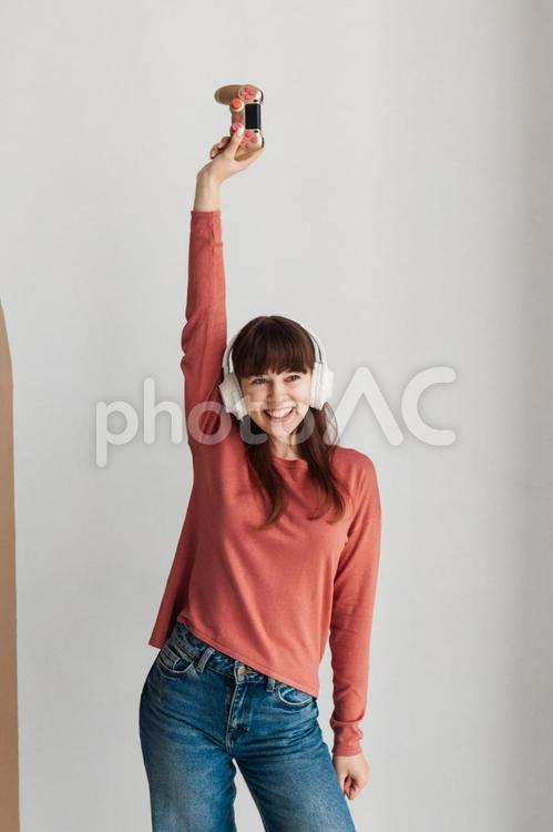 コントローラーを持って腕を上げる女性 女性,人物,若者の写真素材