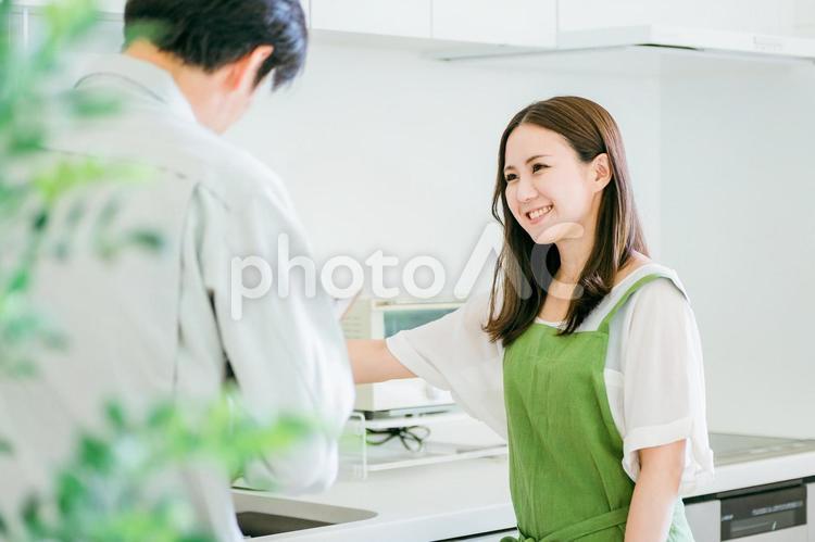 キッチンで話す作業着姿の男性と女性 水道屋,水漏れ,漏水の写真素材