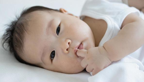 寝ながら指しゃぶりをする子供 寝ながら指しゃぶりをする子供の写真