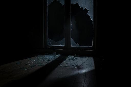 暗い室内と割れたガラス窓 暗い室内と割れたガラス窓の写真